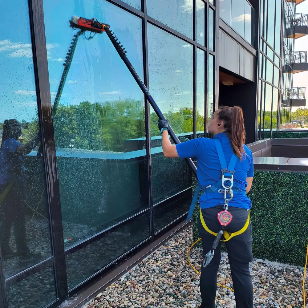 Expert window cleaning technician using eco-friendly solutions to enhance the clarity and shine of large office windows in Tampa Bay